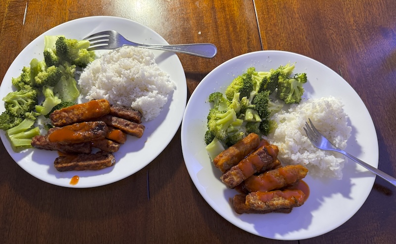 photo of dinner the other night: two plates with white rice, broccoli and buffalo tempeh covered in hot sauce