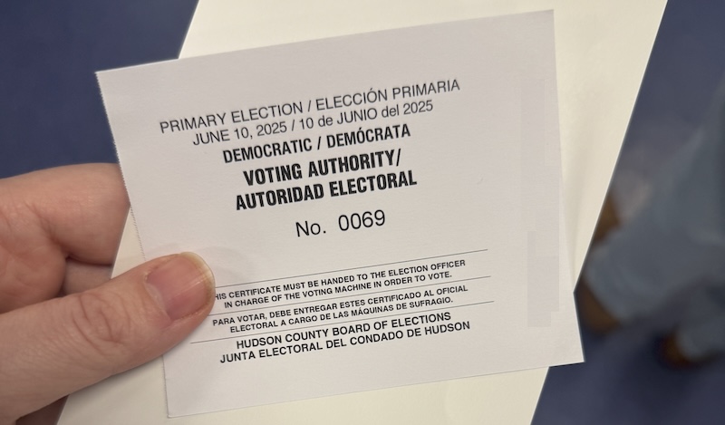 my hand holding my election certificate as i wait in line to vote, my number is 69