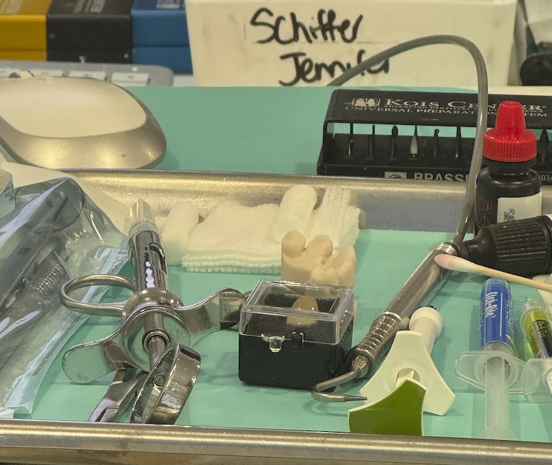 photo of a dentist stand with a bunch of tools and my name is labeled in the background. these are all the needles and drills and stuff needed to replace my crown