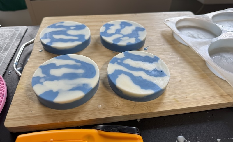 photo of some short, cylindrical, blue sky candles i have curing on a board