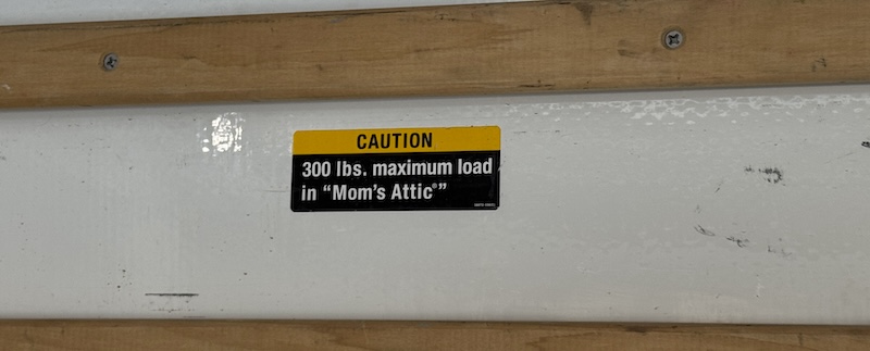 photo of a sticker inside the uhaul truck that says "caution. 300 lbs. maximum load in "mom's attic"