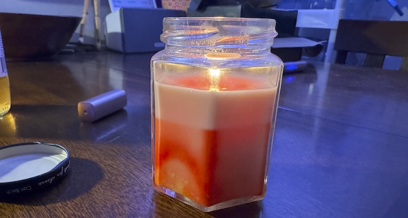 photo of my marbled hexagon candle jar lit and the wax is a solid light color from where it was previously melted, but the wax below it is marbled with red dye