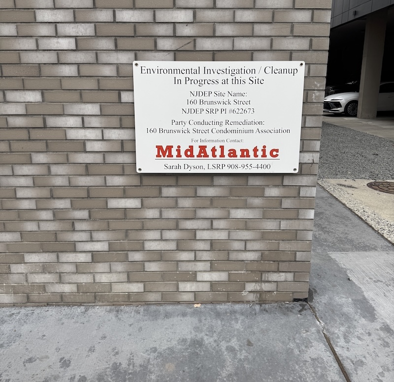 a sign on a building that says "Environmental Investigation / Cleanup
In Progress at this Site"