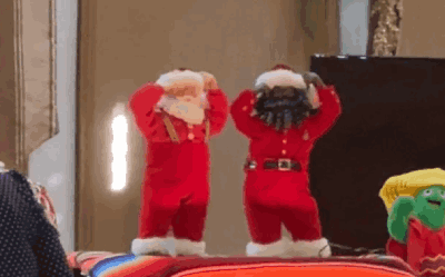 animated gif of the same white santa toy i have, dancing next to a Black santa, both along other holiday toys at a nursing home