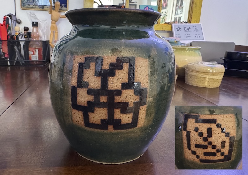 a photo of of a big, tall green vase with a pixel art flower painted onto it in black. there's a cropped photo to the side of one of the pixel art leaves i painted on it