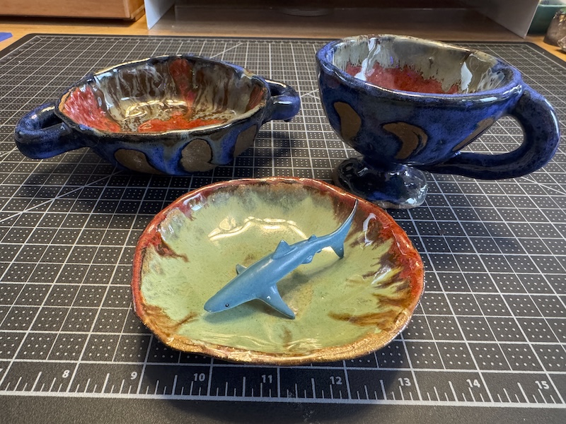 three pinch pots i made, one a little casserole dish, another little goblet, and a small little tray that i have a small shark toy inside to show how small it is