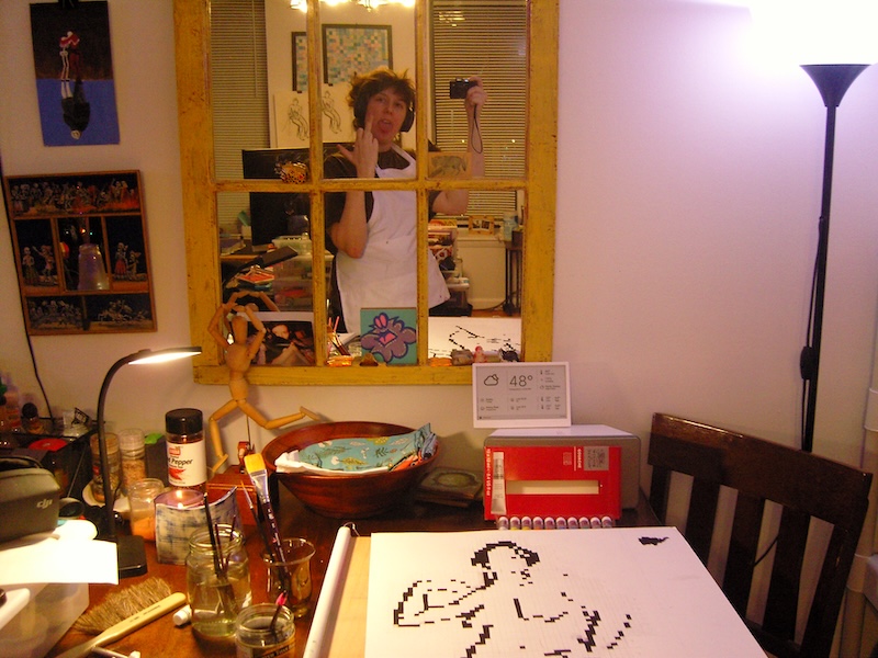 photo of me starting the first pixel figure study on my dining room table, i'm reflected in the mirror on the wall and giving the finger (endearingly)