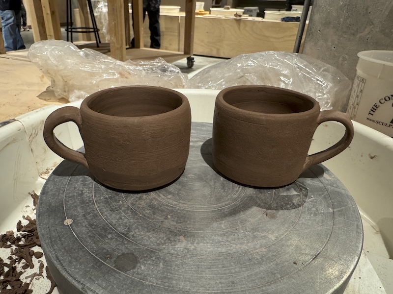 photo of two reddish clay mugs i threw in ceramics and attached handles to