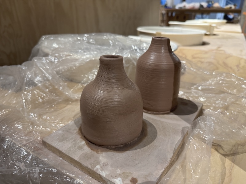 photo of two ceramic bottles i threw on the wheel, sitting together to dry on a board