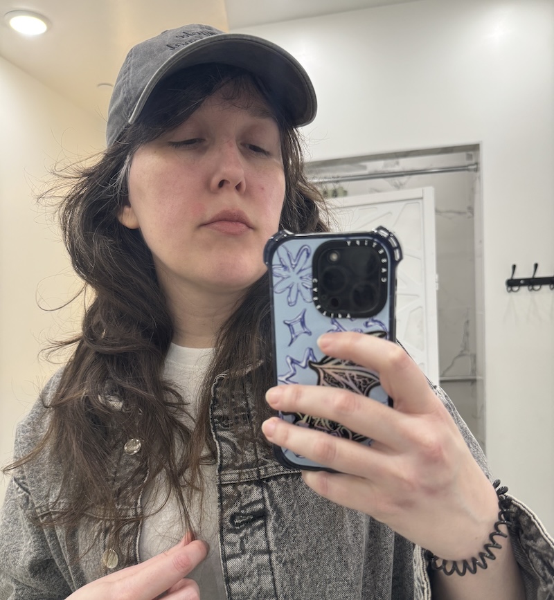 selfie of me in the locker room after a workout and dressed to go, showing off my new blue phone case