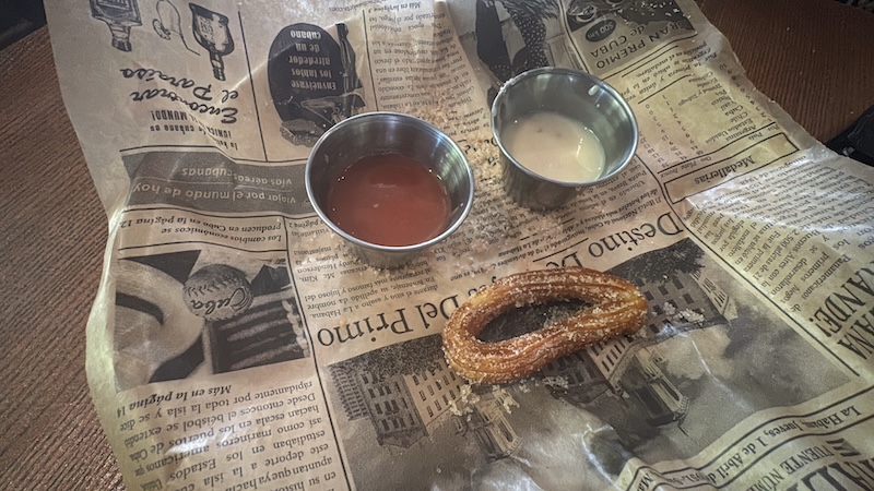 photo of a face i made out of a little churro and sauce dishes at a local cuban restaurant