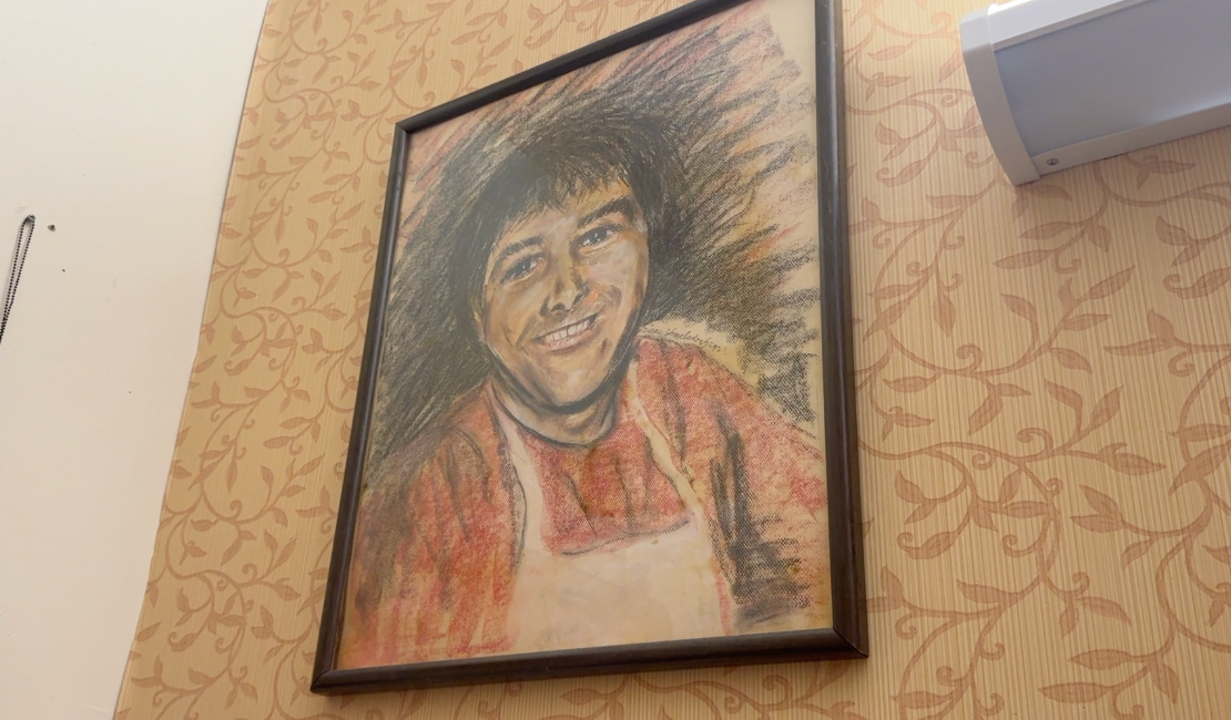 photo of a charcoal portrait of my dad hanging up on his wall
