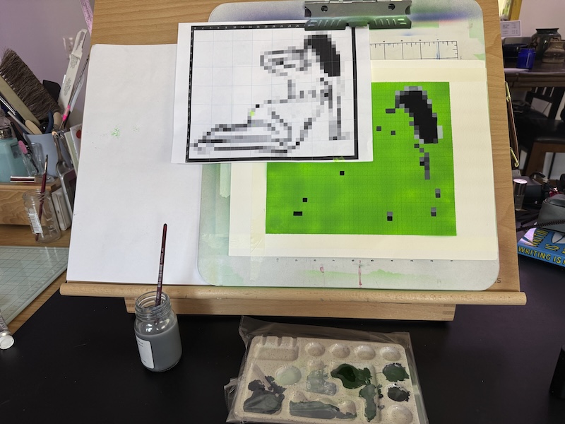 a photo of my in-progress pixel art figure painting on a green background. it's on my desk easel about 1/5th of the way done