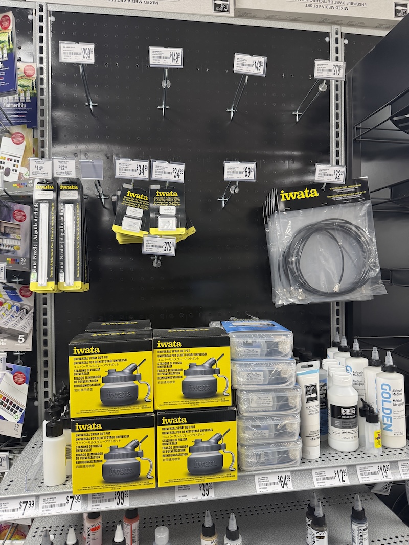 a photo of a section of michael's (a big-box craft store) that's dedicated to iwata brand (airbrush) products. most of the expensive items are not there and everything that is there is unlocked and available which is very rare for these kinds of products in nyc