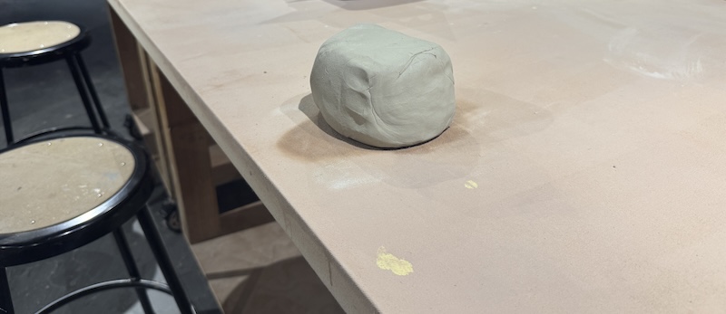 a photo of a wedged ball of white clay on a table in the ceramic studio before i turn it into a thing