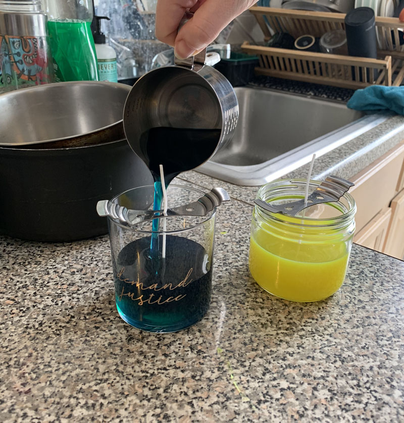 two candles, one is full of melted wax and the other i'm pouring wax into