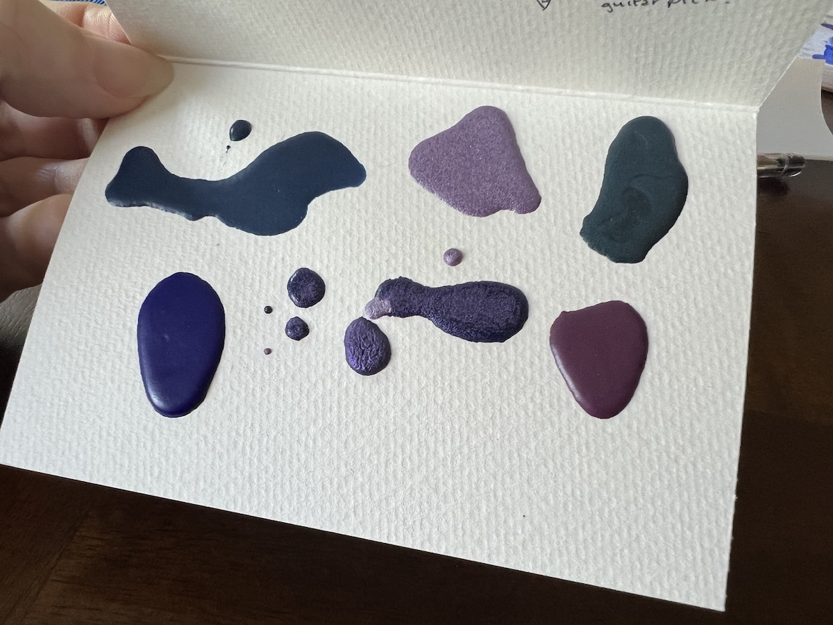 photo of a watercolor paper card with blobs of dried watercolor paint on it, a mini custom palette