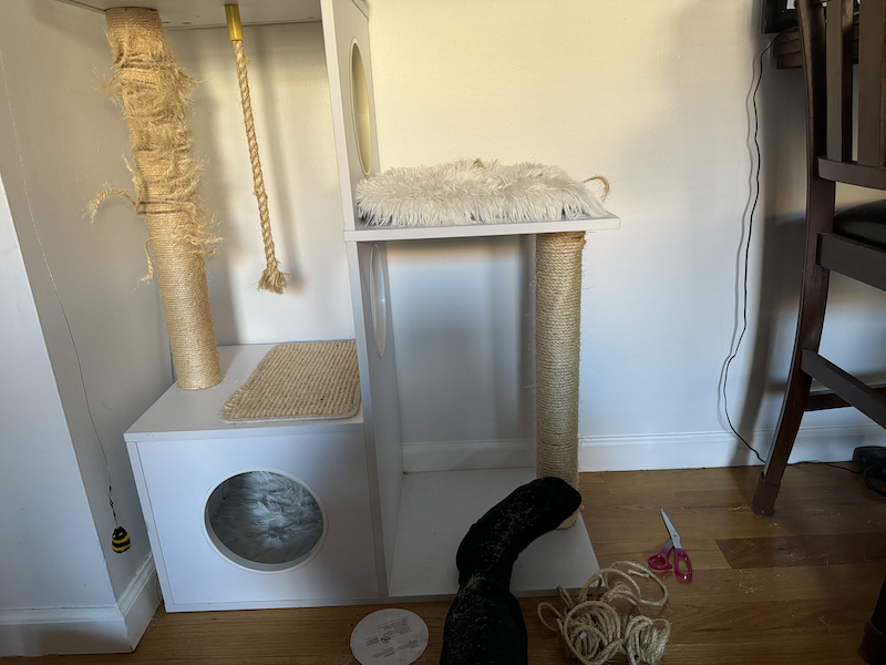 photo of one scratching post of the two complete, and a small pile of rope on the ground