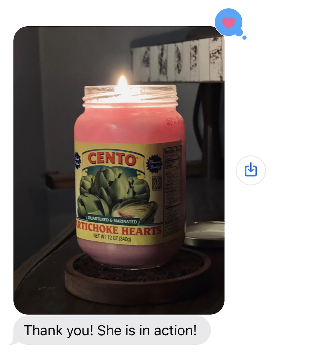 screenshot of an imessage from phil showing a photo of a Cento jar candle lit that's pinkish in color, and phil said "thank you! she's in action!"