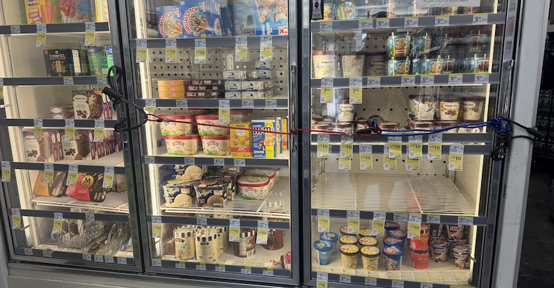 photo of the fridges in duane reade full of ice cream but bungee corded and locked shut