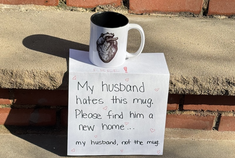photo of a mug on a sidewalk that has a human heart on it. the sign for it says "free! my husband hates this mug. please find him a new home...my husband, not the mug"