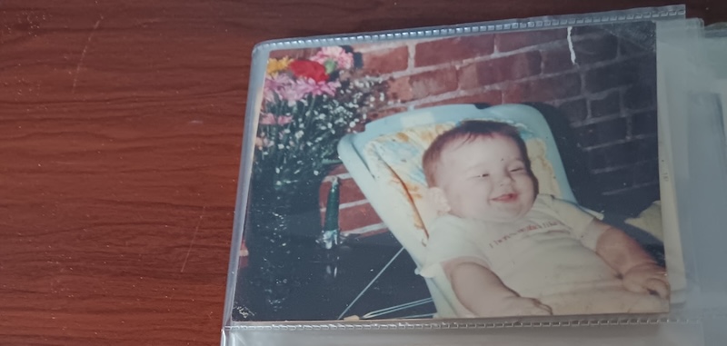 photo of a table and on it is a photo album turned to a photo of me as a baby