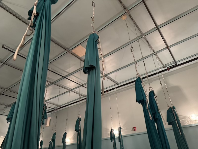 photo of a ceiling of my aerial yoga studio showing turquoise silks attached to rigging points