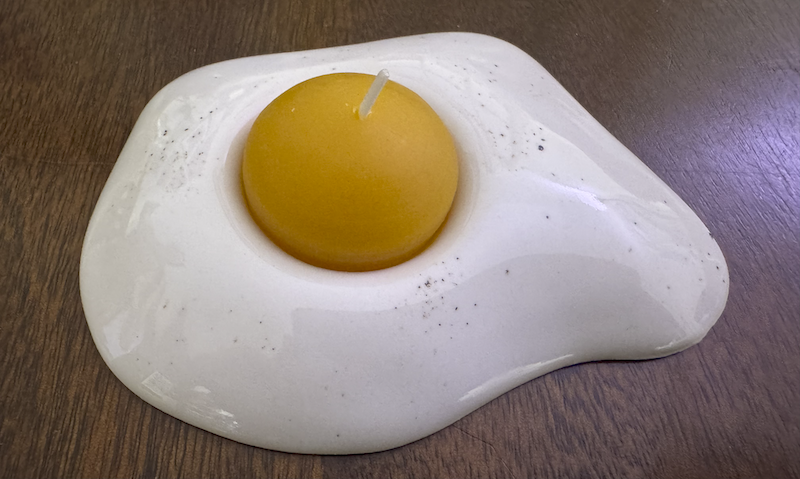 photo of a ceramic sunny side up egg and the yolk is a little beeswax candle