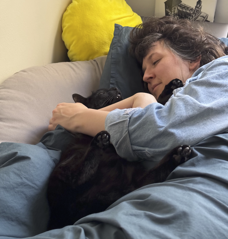 a sweet photo andy took of me and our black cat pumagreg cuddling in bed