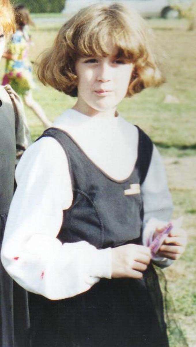 photo of little me dressed in a black dress holding a notepad and there's some fake blood on my sleeve