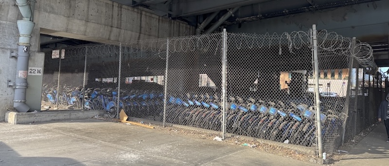 photo of beneath an underpass and the entire fenced-in block is filled with hundreds, maybe thousands of citibikes