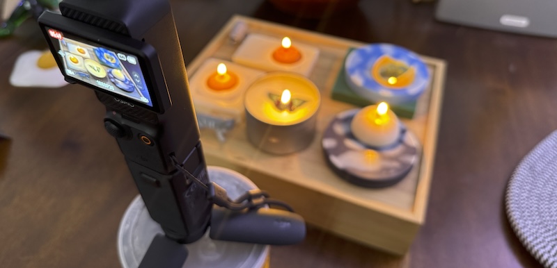 photo of my camera recording video of a candle burn test i was doing. i have two egg candles, a tin candle, and two sky candles