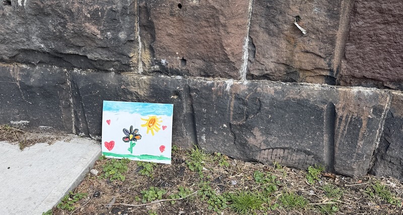a child's painting laid against the embankment wall