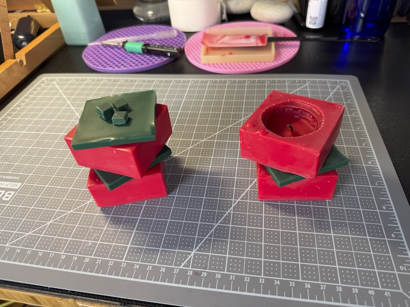 photo of two red and green cube stacked candles on a brand new gray mat i put on my desk