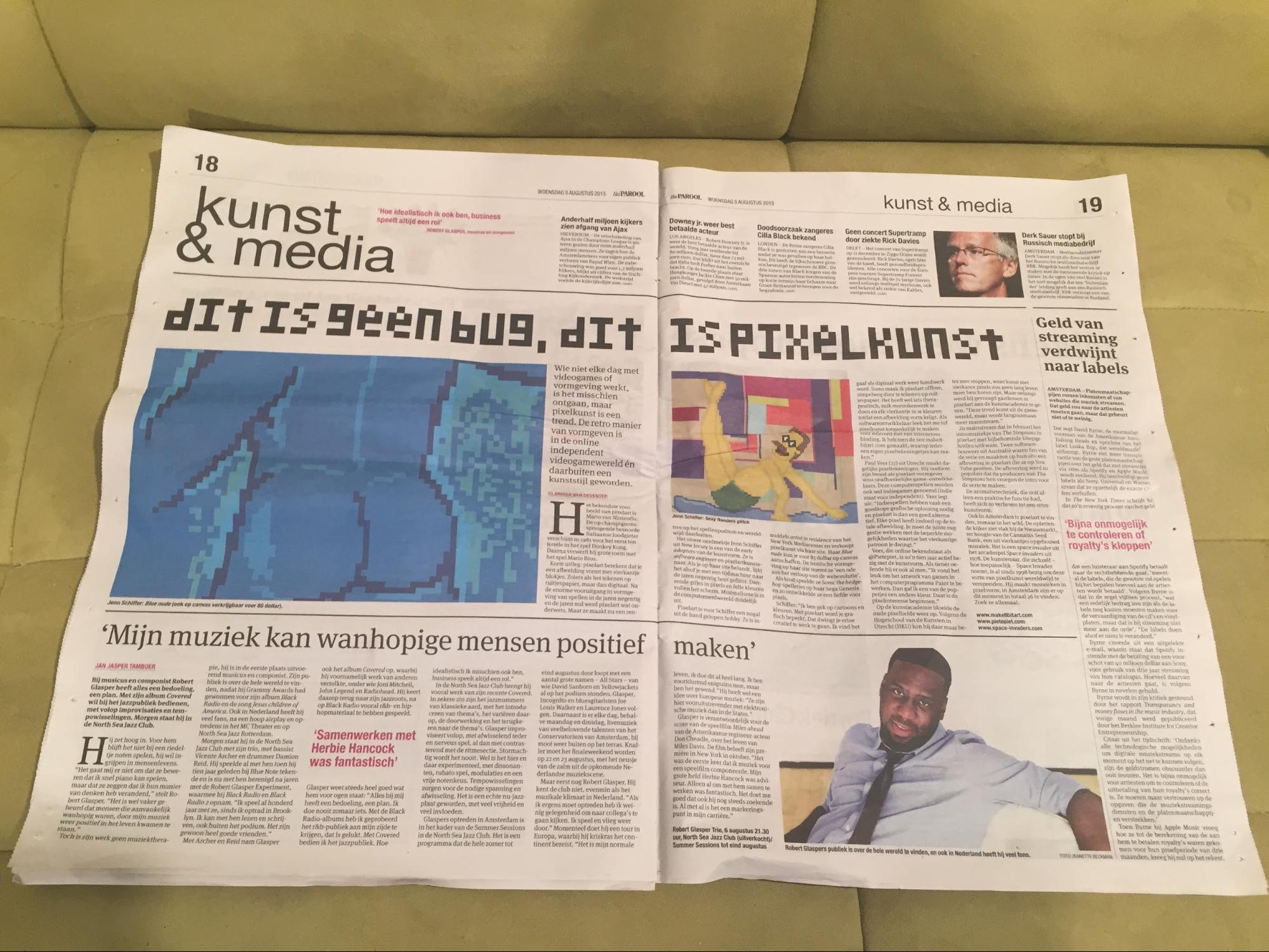 photo of a newspaper, kunst & media, in dutch that has my pixel art on it - a blue nude and a pinup version of ned flanders