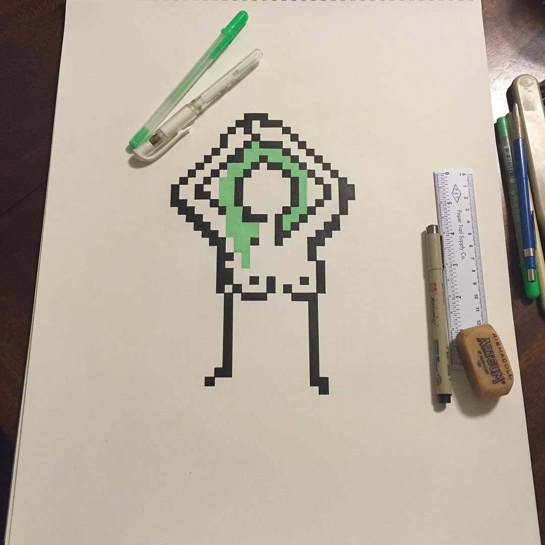 an ink pixel art drawing i made of a nude woman with green hair. you see my pens and ruler and other tools