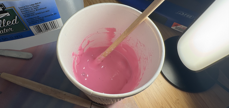 a photo of inside a paper cup filled with bright pink goo