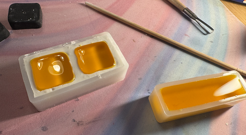photo of the butter mold filled with melted yellow wax and a separate mold filled with yellow wax that i had made extra of
