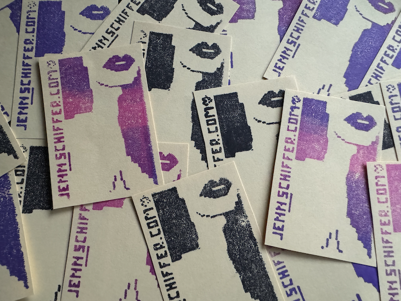 photo of my hand-stamped "business card" that's a pixel babe drawing and it says "jennschiffer.com" with a little heart after it