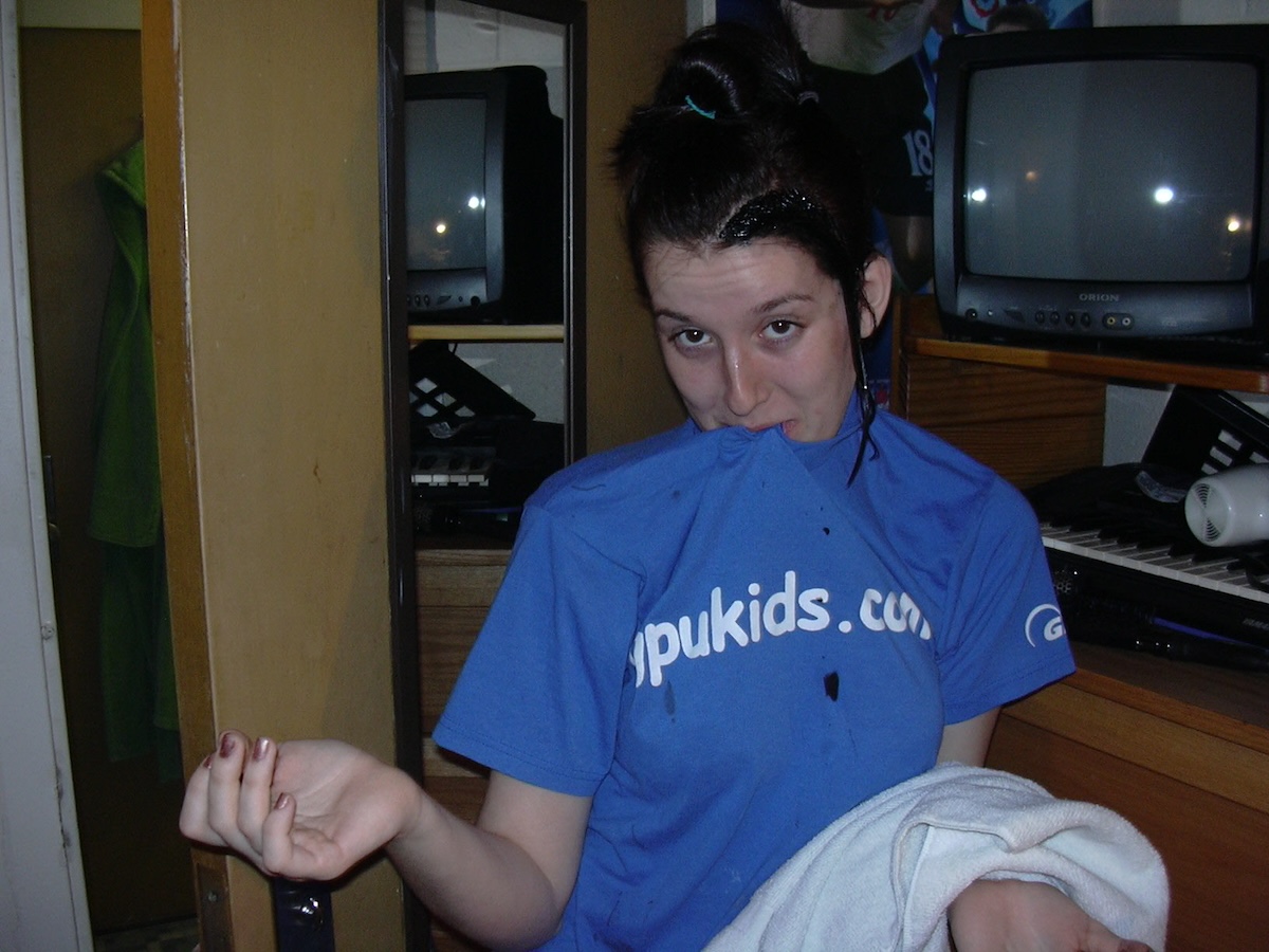 photo of me with my hair looking like a shirt about to get tie-dyed, and my then-blonde streaks were wet with black dye. i'm wearing a shirt that says gpukids.com.