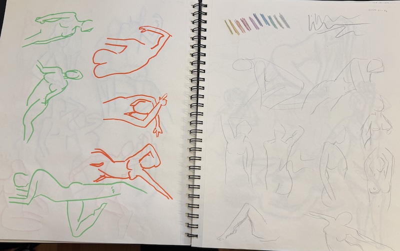photo of my large sketchbook open to two pages of quick nude figure sketches. on the left page are green and orange figures in paint marker, on the right page are figures in graphite.