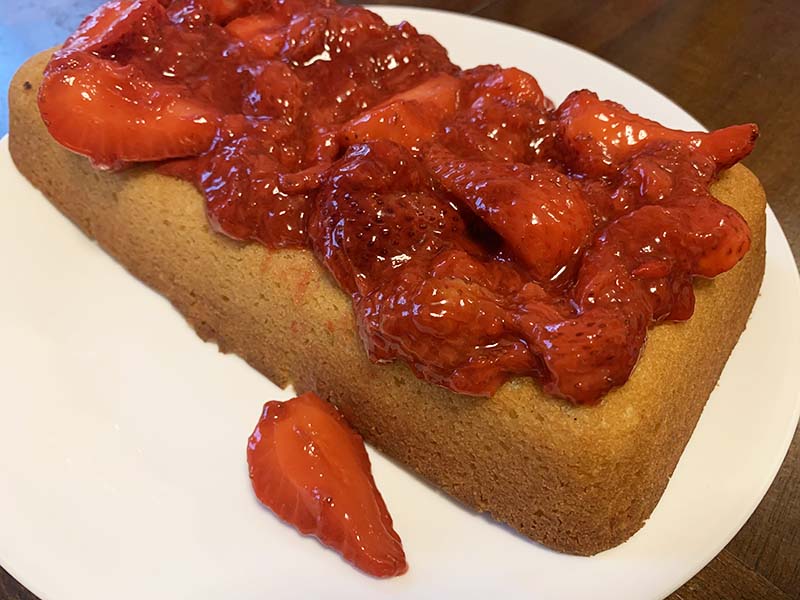 the full cake on a plate with strawberry compote topping