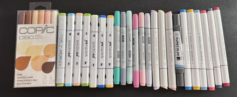 29 alcohol markers of different brands, lined up in a row on my desk