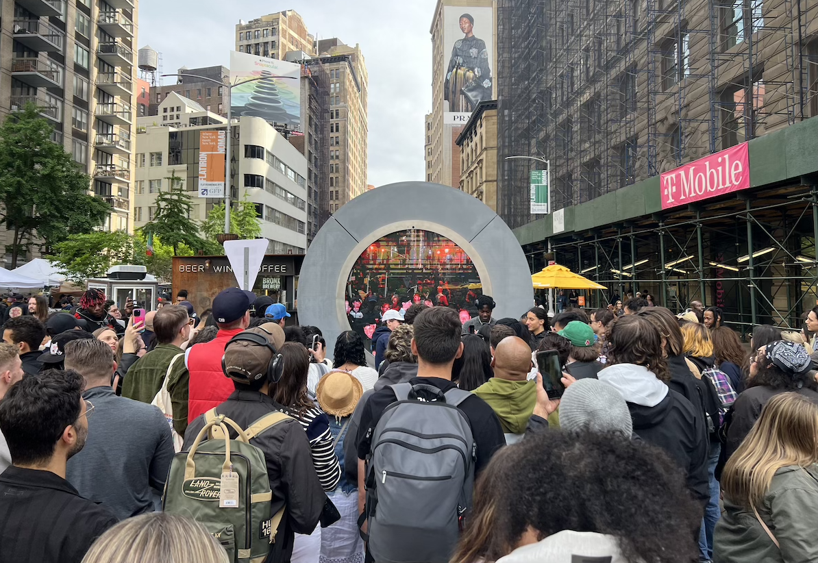 photo of a crowd in front of the large portal in nyc, a large screen showing people in dublin in front of their own part of the installation