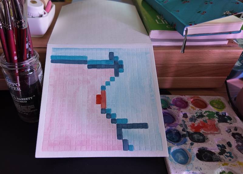 photo of pixel watercolor sketchbook on page 5, a pixel portrait of a boob, with blue skin