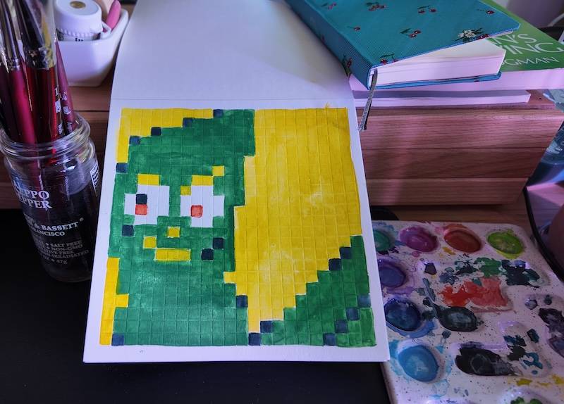 photo of pixel watercolor sketchbook on page 15, a pixel portrait of gumby, the green clay thing