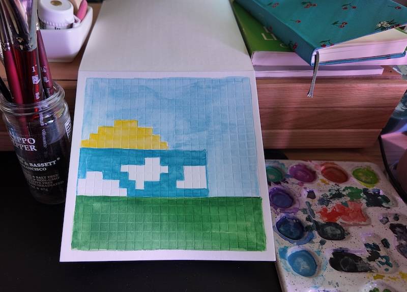 photo of pixel watercolor sketchbook on page 16, a pixel painting of a candle i made - the bottom block is green like grass, the middle has clouds and blue sky, and there's a half sphere of yellow on top representing the sun