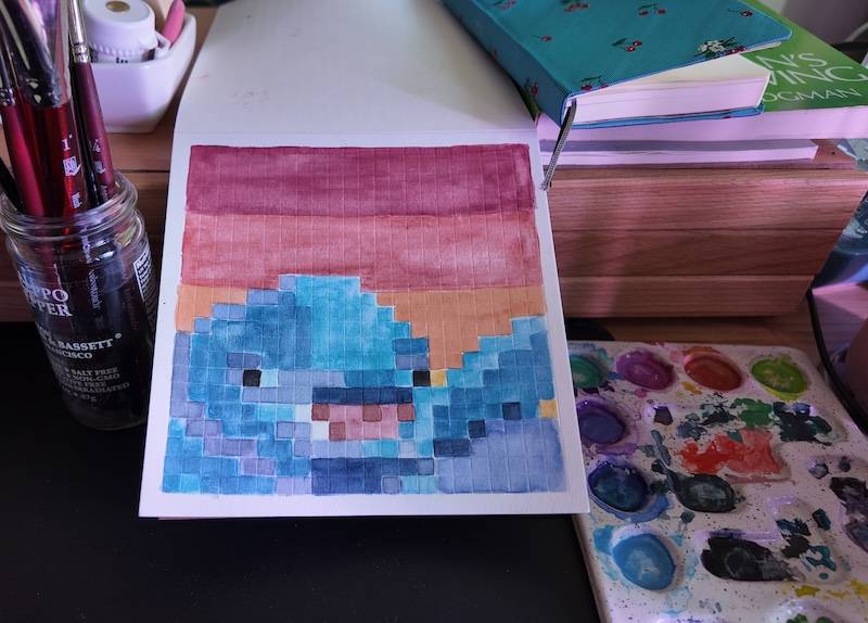 photo of pixel watercolor sketchbook on page 19, a pixel portrait of a dolphin (fin fin, to be exact) witha. sunset-colored background