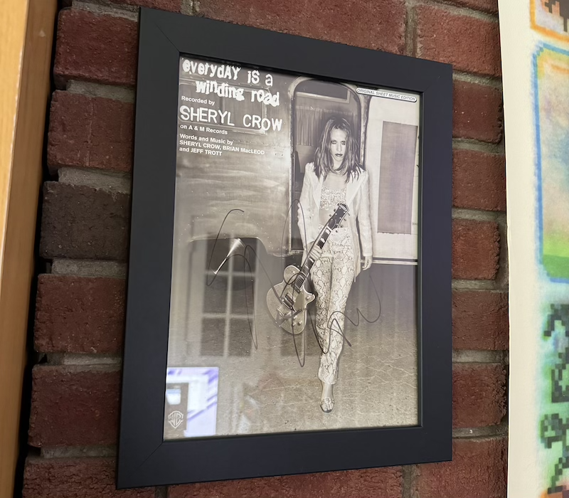 photo of a signed, framed music sheet for sheryl crow's "every day is a winding road"