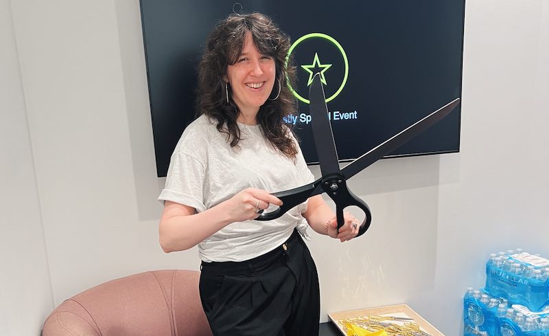 photo of my holding large novelty scissors in the green room of our developer event this past spring
